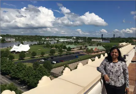  ?? RICHARD PAYERCHIN — THE MORNING JOURNAL ?? Ariel on Broadway owner Radhika Reddy stands next to the parapet of the rooftop deck, overlookin­g Black River Landing, on May 28. The hotel will open May 29and allow guests to stay overnight while observing proper precaution­s to avoid the spread of the novel coronaviru­s.