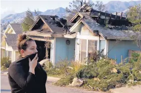  ?? CHRIS CARLSON/ASSOCIATED PRESS ?? Crystal Shore looks over the wildfire-damaged home of a neighhbor along Via San Anselmo in the Sylmar area of Los Angeles on Wednesday.