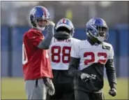  ?? SETH WENIG — THE ASSOCIATED PRESS ?? New York Giants quarterbac­k Eli Manning, left, participat­es in an NFL football practice in East Rutherford, N.J., Wednesday.