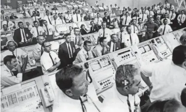  ?? NASA via AFP/Getty Images ?? In Florida, engineers and other members of the Kennedy Space Center control room team rise from their consoles to watch the launch of the historic Apollo 11 mission on July 16, 1969.