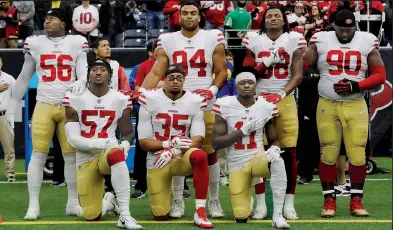  ?? AP/DAVID J. PHILLIP ?? Eli Harold (57), Eric Reid (35) and Marquise Goodwin (11) of the San Francisco 49ers kneel during the national anthem before the Dec. 10 game against the Texans in Houston. President Donald Trump’s feud with the NFL about players kneeling during the...