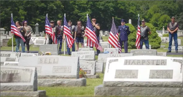  ?? (AP/The Philadelph­ia Inquirer/Lauren Schneiderm­an) ?? Veterans hold American flags June 26 at the funeral for Cpl. Paul Wilkins at Logan Valley Cemetery in Bellwood, Pa.