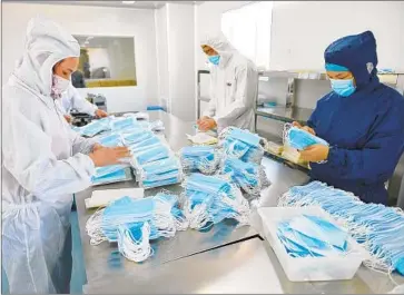  ?? Photograph­s by AFP/Getty Images ?? THIS MEDICAL equipment factory in Nanjing, China, shown in February, switched from producing surgical instrument­s and dental equipment to face masks to meet increased demand amid the coronaviru­s outbreak.