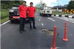  ??  ?? Dr Ting (left) poses at a pothole at Jalan Piasau.