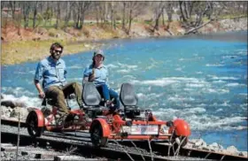  ?? TANIA BARRICKLO—DAILY FREEMAN ?? J.R. and Michelle Davis of Shandaken sit on one of the rail bikes on a section of track above the Esopus Creek outside of Phoenicia, N.Y.