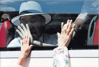  ??  ?? The Associated Press South Koreans on a bus touch the window in their attempt to feel hands of their North Korean relatives as they bid farewell Wednesday after the separated family reunion meeting at the Diamond Mountain resort in North Korea.