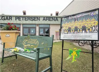  ?? LIAM RICHARDS ?? Green and yellow ribbons and a photo showing the players and staff who died in the April 6 bus crash mark the entrance to Elgar Petersen Arena before the Humboldt Broncos’ season opener against the Nipawin Hawks in Humboldt on Wednesday.