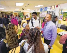  ?? Rogelio V. Solis Associated Press ?? PRINCIPAL Bobby Brown, right, speaks with students as they walk to class at Jim Hill High School, a campus with infrastruc­ture issues in Jackson, Miss.