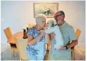  ?? MIKE STOCKER/SOUTH FLORIDA SUN SENTINEL ?? Simon Sherman and his wife Lyuba in their dining room with their dog on July 14.