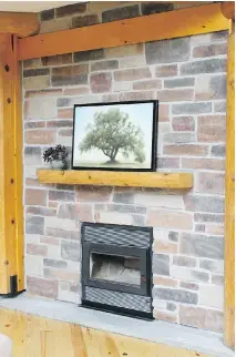  ??  ?? A two-way brick fireplace with red pine mantel faces the great room and master bedroom. The home features five bedrooms in all.