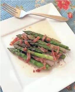  ?? ANNA THOMAS BATES ?? Hot bacon dressing works equally well on asparagus as it does on fresh spinach.