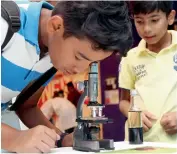  ??  ?? THE MACRO LENS... A boy observes an onion peel under the microscope at the Bio Observatio­n Station.