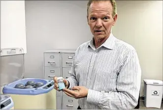  ?? THOMAS GNAU / STAFF ?? Mike Sieron, president and COO at Washington Twp.’s P&C Pharma, shows a bottle of flavored liquid medicine that has recently gone through the company’s proprietar­y process.