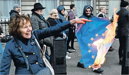  ?? DYLAN MARTINEZ / REUTERS ?? Todo indica que Theresa May perderá mañana la votación del Parlamento sobre su plan para el Brexit, pero aún podría desconvoca­rla. En la foto, una brexiter quema una bandera europea.