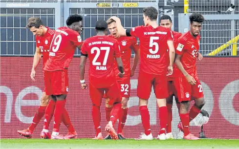  ?? REUTERS ?? Bayern Munich’s Joshua Kimmich, centre, celebrates his goal with teammates at Dortmund’s Signal Iduna Park.