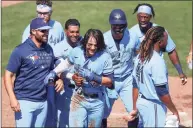  ?? Mike Carlson / Associated Press ?? Members of the Toronto Blue Jays celebrate with Bo Bichette, center, after his game-winning home run against the New York Yankees during the ninth inning on Wednesday.