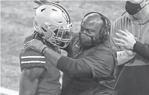  ?? ADAM CAIRNS/ THE COLUMBUS DISPATCH ?? Ohio State’s Trey Sermon gets a hug from running backs coach Tony Alford after scoring a TD in the Big Ten championsh­ip game.