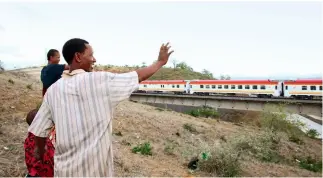  ?? Xinhua ?? 29 de abril de 2017. La gente de la ciudad de Mombasa ve pasar el tren Mombasa-Nairobi, el primer ferrocarri­l de Kenia después de su independen­cia, construido por una empresa china.