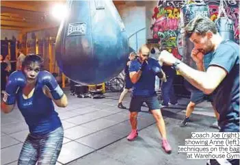  ?? ARSHAD ALI/©Gulf News ?? Coach Joe (right) showing Anne (left) techniques on the bag at Warehouse Gym