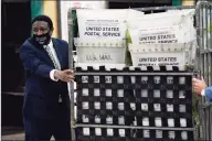  ?? Lynne Sladky / Associated Press ?? Broward County Mayor Dale V.C. Holness helps load vote-by-mail ballots into a truck for transport to a local U.S. Postal Service office at the Broward Supervisor of Elections Office, Thursday in Lauderhill, Fla. Vote-by-mail ballots will begin going out to residents in Broward County Thursday.