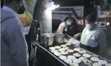  ?? SALVADO MELENDEZ, THE ASSOCIATED PRESS ?? Gertrudis Hernandez sells “pupusas” at a bus stop in San Salvador, El Salvador, before sunrise Tuesday, the day all businesses have to accept payments in Bitcoin, except those lacking the technology to do so.