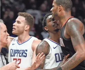  ?? ROBERT HANASHIRO/USA TODAY SPORTS ?? The Rockets’ Trevor Ariza, right, is restrained by the Clippers’ Lou Williams on Monday in Los Angeles.