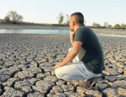 ??  ?? A man looks at the dry land next to a depleted pond, in Edirne, Turkey, Sept. 25, 2020.
