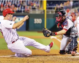  ?? (TNS) ?? PHILADELPH­IA PHILLIES baserunner Tommy Joseph scores under the tag of Washington Nationals catcher Matt Wieters on a two-run double by Cameron Rupp in the third inning of the Phillies’ 4-1 home victory over the Nationals on Tuesday night.