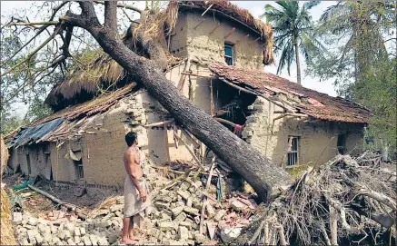  ?? BY SPECIAL ARRANGEMEN­T ?? A man stands next to a house damaged in Cyclone Amphan in Sunderbans region’s Sagar island. n