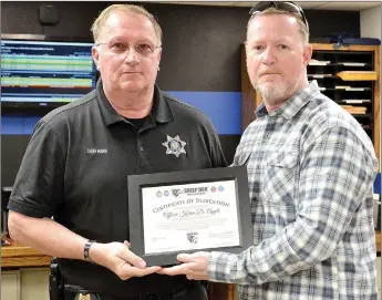  ?? TIMES photograph by Annette Beard ?? Pea Ridge Police Chief Lynn Hahn, left, received a plaque from St. Major Lance Nutt, president, founder of Sheep Dog Impact Assistance Thursday, March 10. A portion of a lodge will be named in honor of former Pea Ridge Police Officer Kevin Apple.
