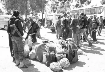  ?? — AFP photo ?? Syrian civilians and rebel fighters arrive in the village of Qalaat al-Madiq, some 45 kilometres northwest of the central city of Hama as evacuation­s from Eastern Ghouta continued following a deal that was announced earlier in the week.