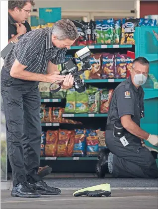  ?? Photo: ROBERT KITCHIN/FAIRFAX NZ ?? Combing for clues: Police examine the scene of a robbery at the Caltex petrol station on the corner of Main and Ruahine streets in Palmerston North yesterday.