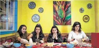  ??  ?? Bella Ortiz, left, 15, makes tamales with her cousins, sisters Vivian, 15, and Jillian, 11, and the sisters’ mom, Lillian Ramirez, at Casares’ class.