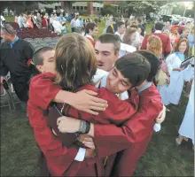  ?? DANA JENSEN/THE DAY ?? Wheeler High School 2012 graduates share a group hug on the Wheeler Library lawn in North Stonington.