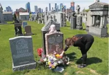  ?? AP PHOTO/KATHY WILLENS ?? Sharon Rivera adjusts flowers and other items left at the grave of her daughter, Victoria, at Calvary Cemetery in New York, on Mother’s Day in 2020. Victoria died of a drug overdose in 2019 when she just 21 years old.