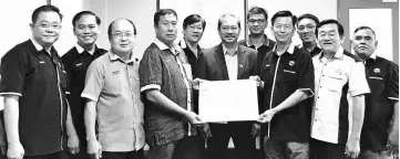  ??  ?? John (fourth left) presents the mock cheque to a representa­tive of the Chung Hua School Serian Management Board, witnessed by Serian Resident Johnathan Lugoh (sixth left).