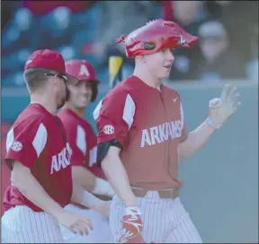  ?? NWA Democrat-Gazette/Andy Shupe ?? FRESHMAN OF THE YEAR: Arkansas left fielder Heston Kjerstad, right, was given the Hog hat by Hunter Wilson after Kjerstad hit a three-run home run on March 1 during the fifth inning of an 11-0 win against Dayton at Baum Stadium in Fayettevil­le....