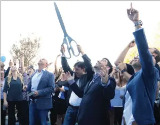  ?? Nikolas Samuels/The Signal ?? Rustin Kretz, CEO of Scorpion Internet Marketing, and his brother, Jeff Kretz, holding the scissors, celebrate the ribbon cutting for Scorpion’s new headquarte­rs in Valencia on Oct. 27, 2017. The Valenciaba­sed internet marketing firm donated $24,000 to...