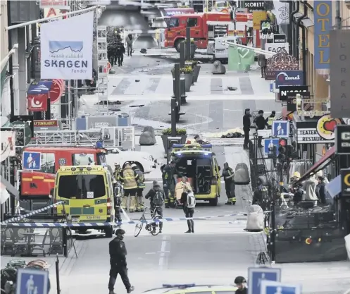  ??  ?? Emergency services work at the scene where a truck crashed into the Ahlens department store at Drottningg­atan in Stockholm