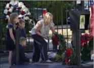  ?? AP PHOTO/DAVID J. PHILLIP ?? Tiffany Utterson, right, and her children, from left to right, Ella, 11, Ian, 10 and Owen, 8, place a wreath outside the gated community entrance to the home of George H.W. Bush on Sunday in Houston.