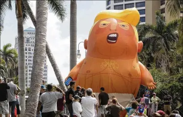  ?? JAMES WOOLDRIDGE / THE PALM BEACH POST ?? The famous Baby Trump balloon rests on a hill Saturday at a rally at Meyer Amphitheat­re marking the anniversar­y of Hurricane Maria’s landfall on Puerto Rico. A George Washington University study found that almost 3,000 people died on the island after the hurricane, which President Trump afterward disputed in tweets.