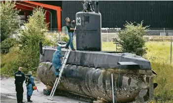  ?? FOTOS: DPA ?? Techniker der Polizei untersuche­n im Hafen in Kopenhagen das selbstgeba­ute U-Boot „Nautilus“während der Suche nach der vermissten schwedisch­en Journalist­in.