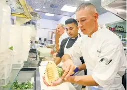  ??  ?? The Beestro’s kitchen team, including Richard Rodriguez, right, Oscar Carvajal, center, and head chef Menke assemble a variety of stuffed pitas Tuesday.