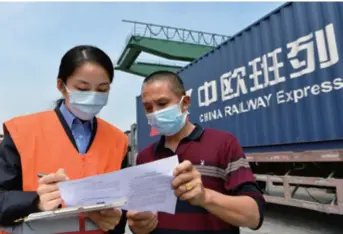  ??  ?? A railroad employee (left) and a shipper’s agent go through procedures for goods delivery by a China-europe freight train in Xiamen, Fujian Province in southeast China, on April 25