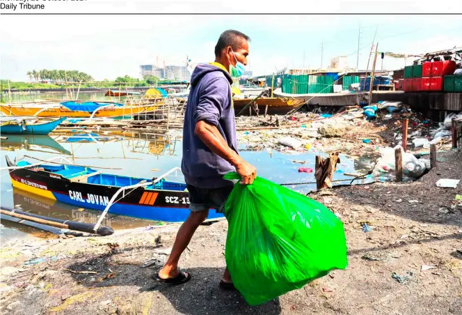  ?? PHOTOGRAPH BY RIO DELUVIO FOR THE DAILY TRIBUNE @tribunephl_rio ?? Sharp contrast Away from the happy crowds at Manila Bay’s dolomite beach, it’s a hard life under the searing heat of the sun for 65-year-old Jaime Hortilano as he gathers recyclable materials off the banks of the Parañaque City fishport. Previously, Hortilano worked 14 years in a sectarian school.
