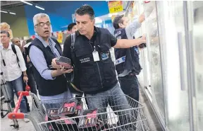  ?? Picture / AP ?? Health and safety officials inspect meat products at a supermarke­t in Rio de Janeiro.