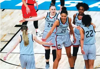  ?? AP PHOTO BY CHARLIE RIEDEL ?? Members of the Connecticu­t women’s basketball team celebrate a score against Syracuse in an NCAA tournament second-round game Tuesday in San Antonio.