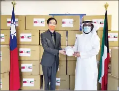  ??  ?? Representa­tive Hua-Wei Mou hands over the supplies to the president of Kuwait Associatio­n of Surgeons.