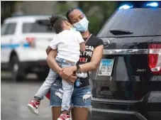  ?? ASHLEE REZIN GARCIA/SUN-TIMES ?? Toccara Hayes holds her son Zion Johnson at an event in Englewood on Monday condemning recent gun violence.