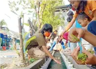  ?? ROBY KURNIAWAN/JAWA POS ?? NOVASI: Mahasiswa KKN Kelompok 31 UPN Veteran Jatim bersama warga RT 2, RW 10, Desa Jati, Kecamatan Sidoarjo, memanfaatk­an saluran buntu untuk kolam lele dan tanaman hidroponik.